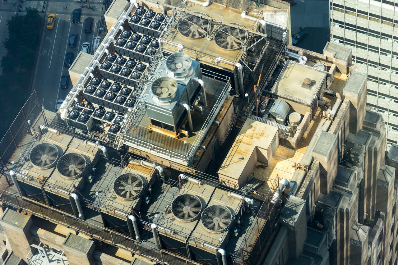 High-angle shot of HVAC units on a city building's rooftop, showcasing industrial infrastructure.